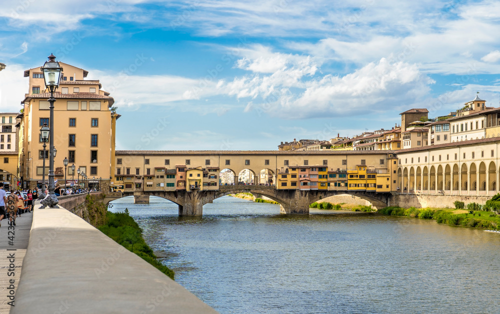 Ponte Vecchio bridge crossing the river Arno, seen from Lungarno Guicciardini i in a bright sunny day, Florence city center, Tuscany, Italy