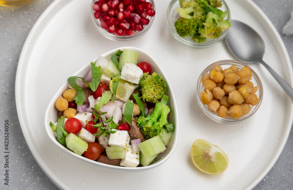 fresh green salad served in a white bowl with beans, legumes, and pomegranate seeds fresh green salad served in a white bowl with beans, legumes, and pomegranate seeds