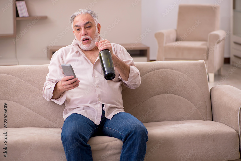 Old man drinking alcohol at home Old man drinking alcohol at home