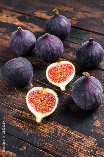 Purple figs on a wooden table. Dark wooden background. Top view