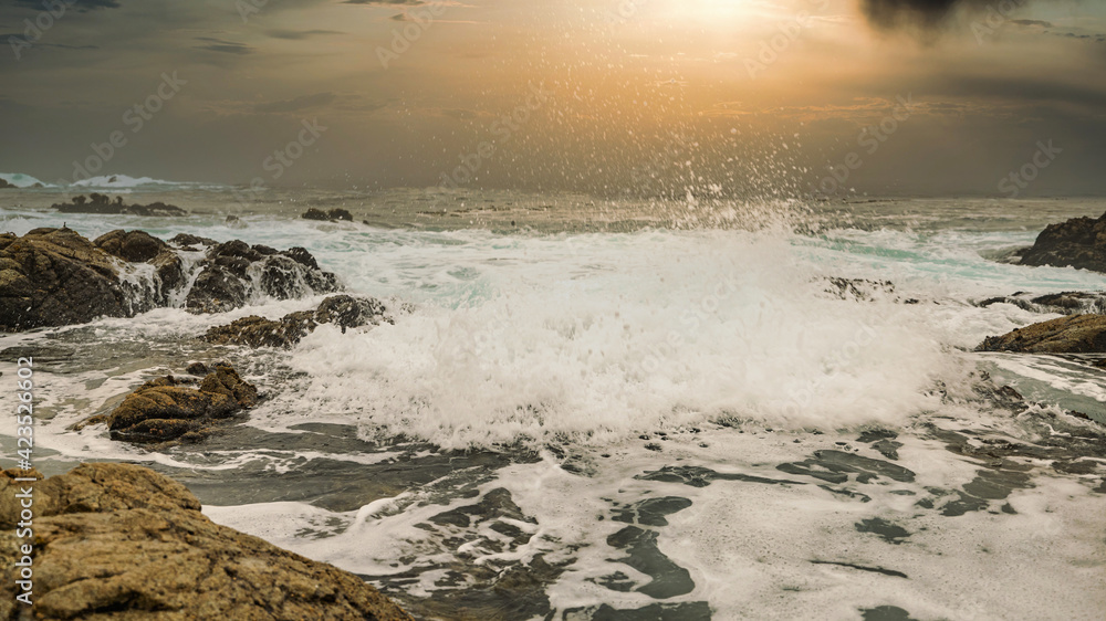 Obraz premium Beautiful seascape, ocean views, rocky coast, sunlight on the horizon. Composition of nature. Sunset scenery background. Cloudy sky. Water Reflection. California Seashore.