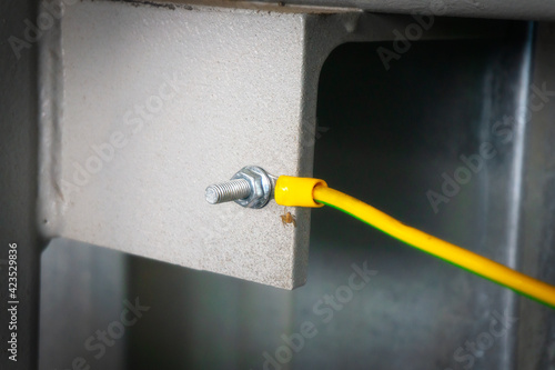 The yellow ground wire is screwed with a bolt and nut to the metal structure