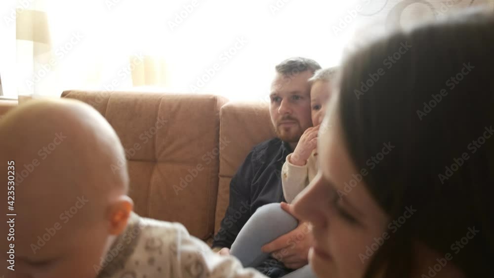 Parents with two children are sitting on the couch Parents with two children are sitting on the couch