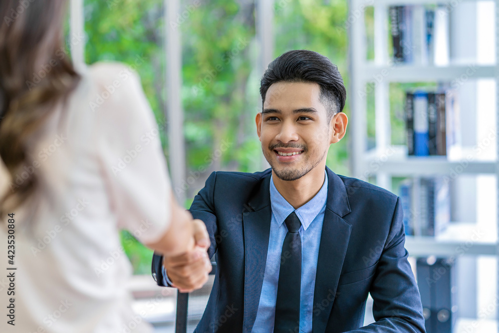 Closeup handshake after interview agreement between Young Asian woman and two manager with positive motion in meeting room, handshake with manager, Business Hiring new member concept,
