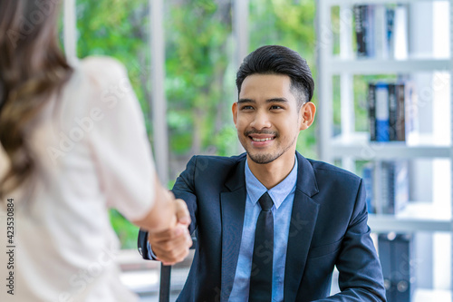 Obraz na płótnie Closeup handshake after interview agreement between Young Asian woman and two manager with positive motion in meeting room, handshake with manager, Business Hiring new member concept, w salonie