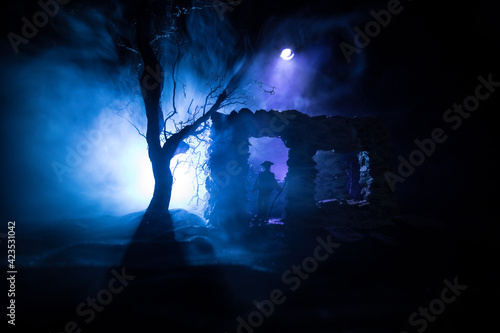 Old ruined stone house in deserted garden at night. Selective focus