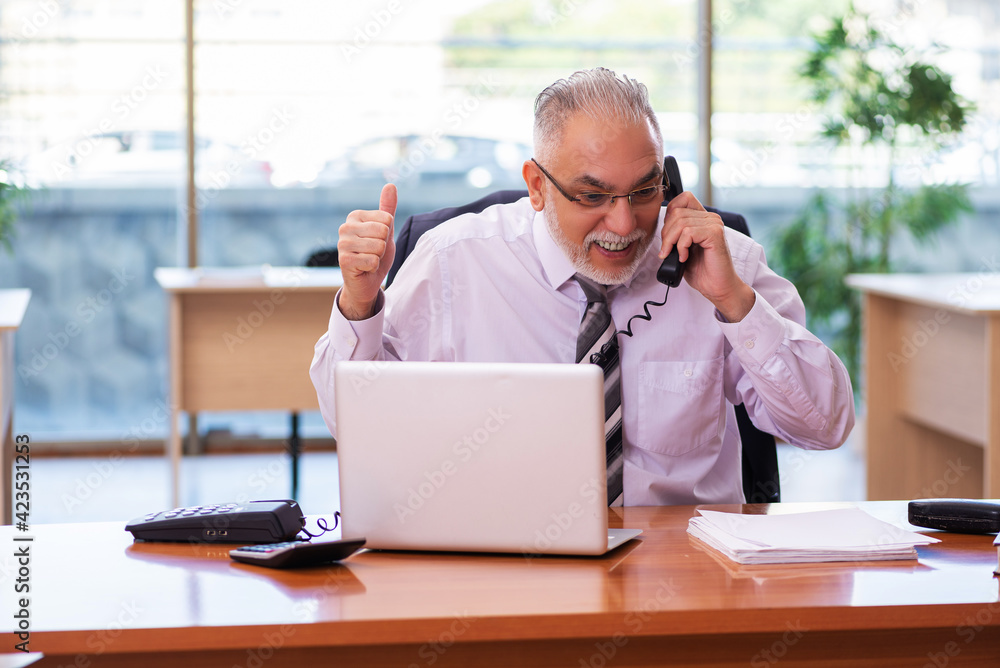 Old businessman employee working in the office Old businessman employee working in the office