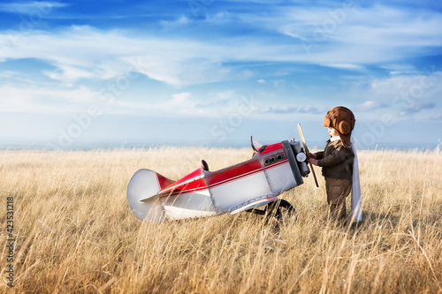 A small child plays with a toy plane, imagines himself as an aviator and dreams of flying.