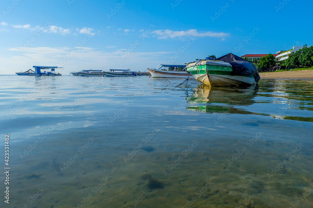 Fishing boat wrapped in blue plastic cloth. Fishing boats that are not operating are anchored on the coast.