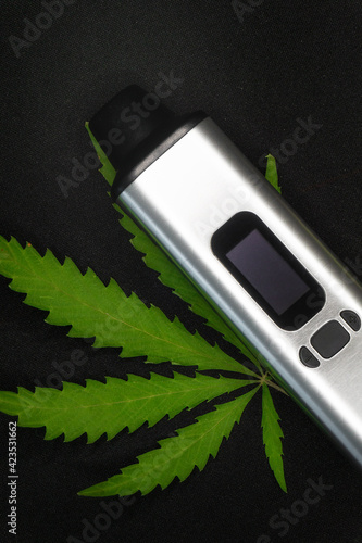 electronic vaporizer with cannabis leaf on black background