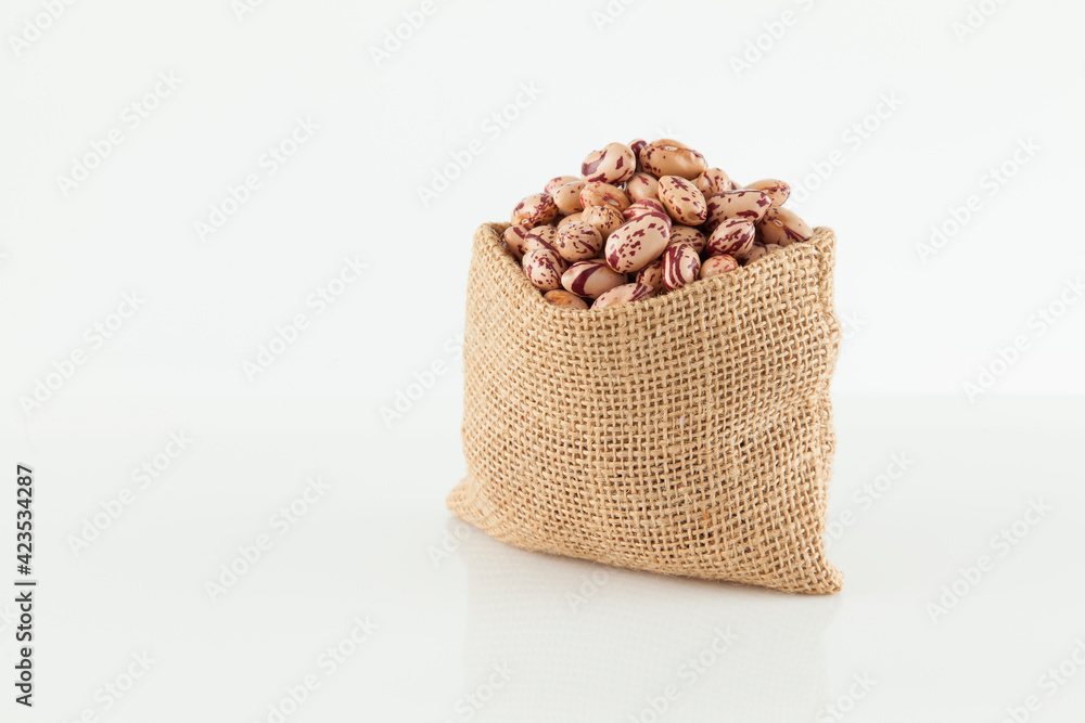 Pinto beans, a legume native to the American continent; photo on white background.