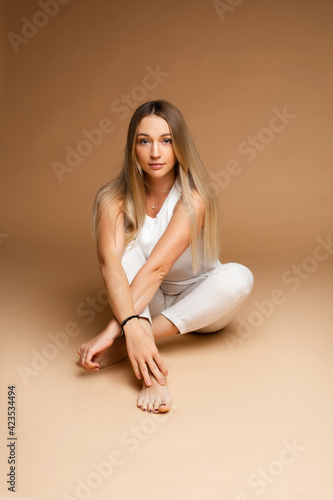 Beautiful Caucasian woman sitting with legs and arms crossed.