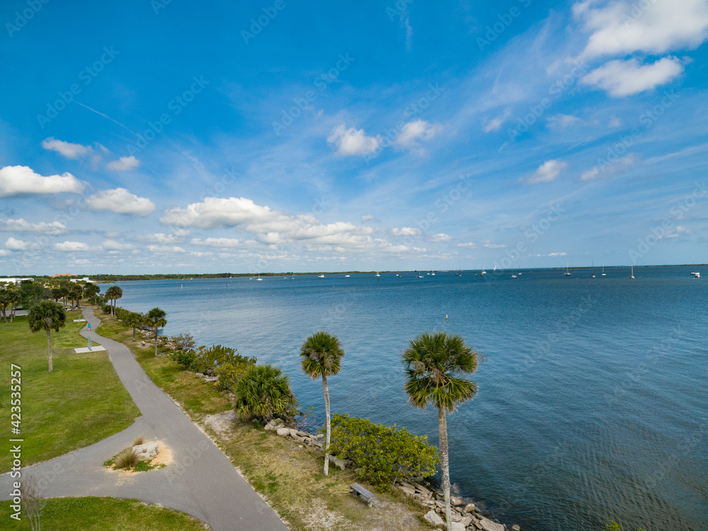 Fototapeta premium Indian River near the City of Titusville Florida on a beautiful morning with palm trees and clouds