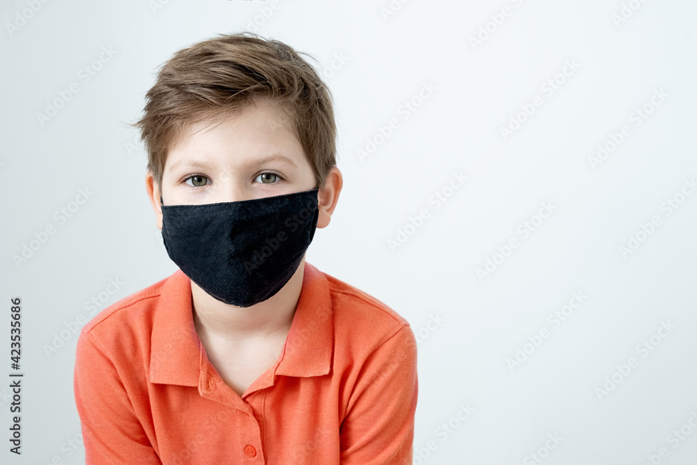 Portrait little smiling caucasian boy in a funny medical mask. Protection against coronavirus in a pandemic. Emotions of a child. Portrait little smiling caucasian boy in a funny medical mask. Protection against coronavirus in a pandemic. Emotions of a child.