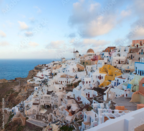 Panoramic beautiful view of Oia town on Santorini island, Cyclades, Greece. Traditional famous white houses, windmills and churches over the Caldera in Aegean sea