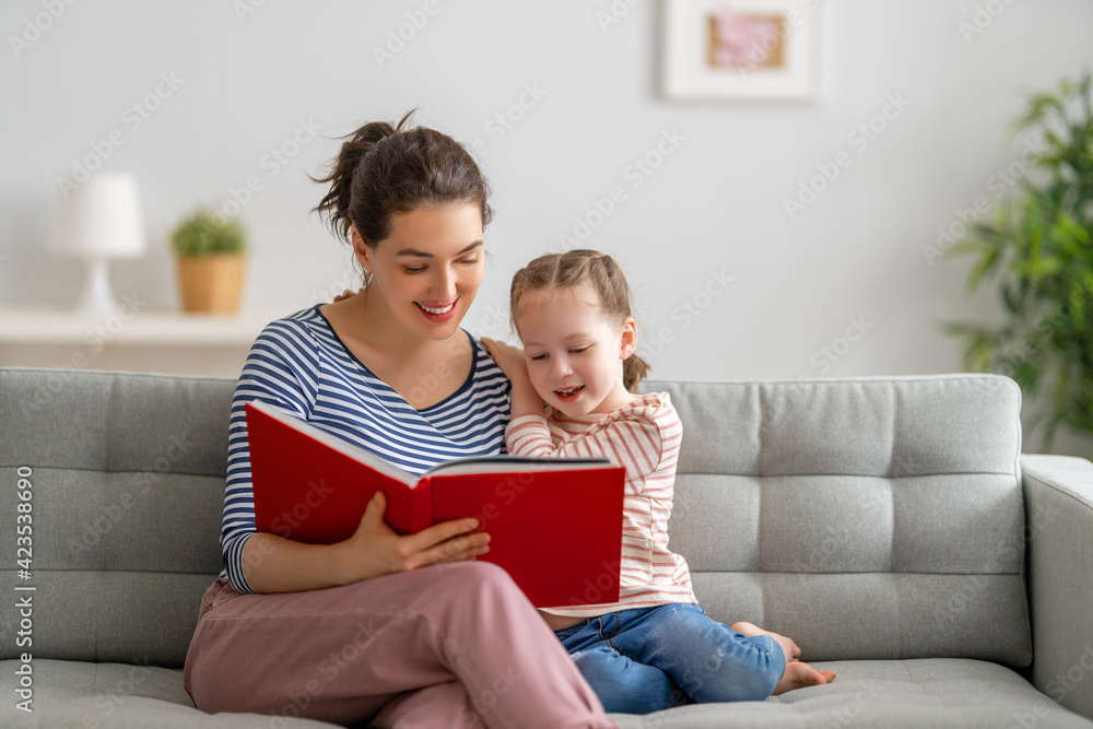 mother reading a book to daughter