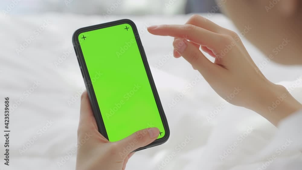 Close up of woman holding in hands a mock up smartphone with green screen for internet online, chromakey screen for advertising. Close up of woman holding in hands a mock up smartphone with green screen for internet online, chromakey screen for advertising.