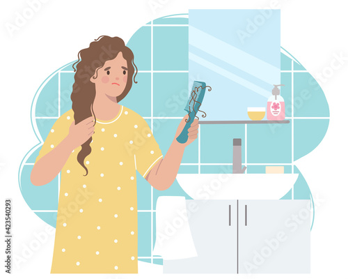Bathroom, woman is holding a comb with a lock of hair, she is upset because of hair loss.