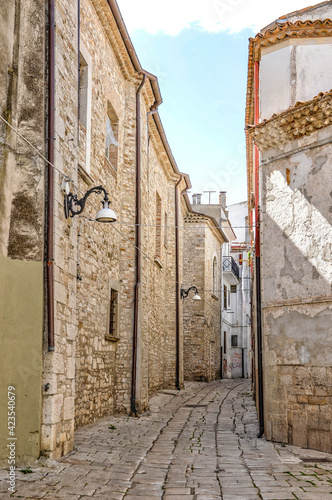 Fototapeta Naklejka Na Ścianę i Meble -  A narrow street among the old houses of Venosa, a medieval village in the Basilicata region, Italy.