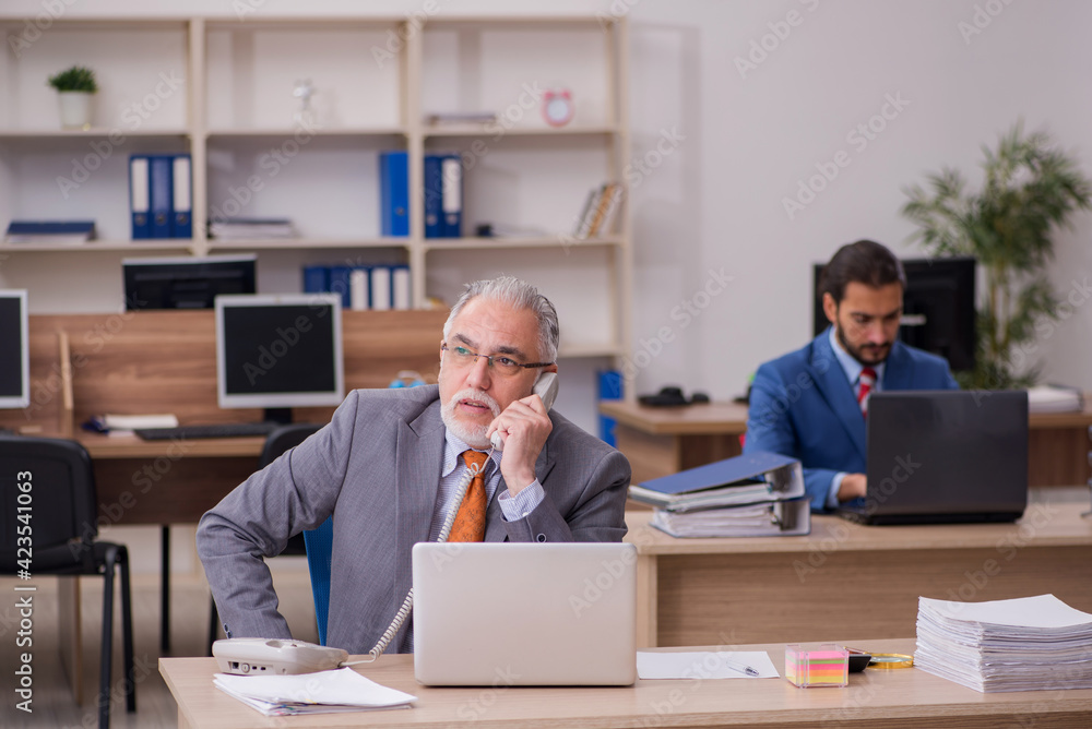 Two male employees working in the office Two male employees working in the office