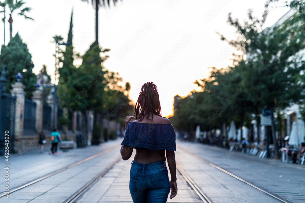 Black woman walking backwards on the city