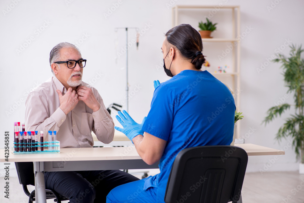 Fototapeta premium Old patient visiting young male doctor