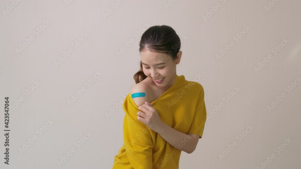 Young attractive beautiful asia female or teenage receive covid-19 anti virus vaccine in campaign vaccination safe life happy smile cheerful with blue, yellow, pink bandage on arm with copy space. Young attractive beautiful asia female or teenage receive covid-19 anti virus vaccine in campaign vaccination safe life happy smile cheerful with blue, yellow, pink bandage on arm with copy space.