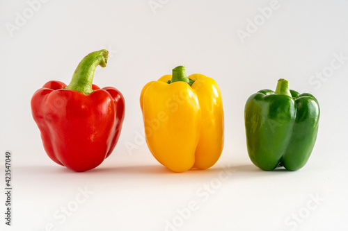 Close-up of three bell peppers in a row on a white background, with copy space