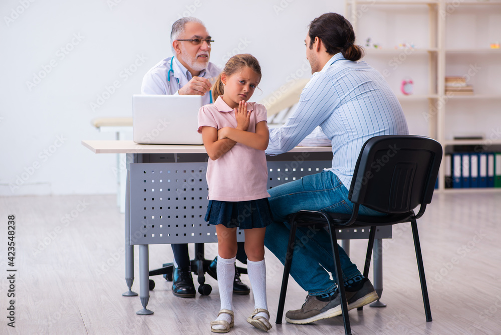 Small girl with her father visiting old male doctor Small girl with her father visiting old male doctor
