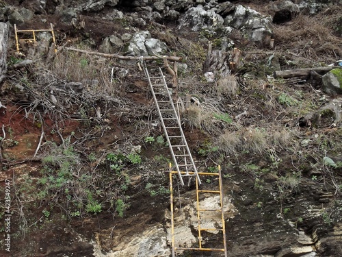 Una escaleras mal colocada en una montaña de rocas  photo