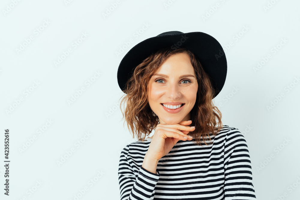 Happy smiling young woman wearing stylish fedora hat and striped shirt Happy smiling young woman wearing stylish fedora hat and striped shirt
