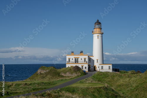 Aerial view of Turnberry Lighthouse, Scotland on a sunny day. View looking out to see over the white lighthouse on a blue sky day. 