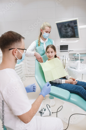 Vertical shot of a young girl getting dental examination at the clinic