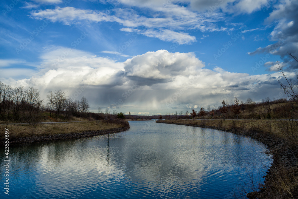 eine Flussbiegung vor bewölktem Himmel