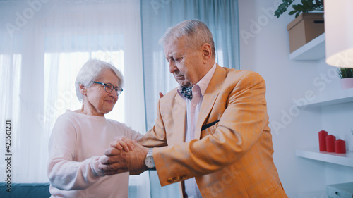Happy elderly couple dancing at home . Love and dating at old age. High quality photo