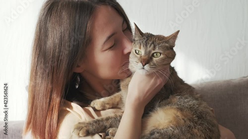 Beautiful girl rubs nose and cheek on his cat.
