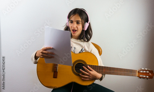 girl giving online guitar lessons, concept study from home online