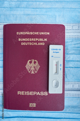 German passport with negative covid-19 result. Blue mouth and nose masks. Top view. photo