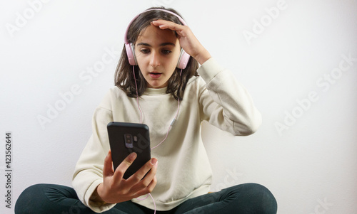 girl watching videos and social networks on the mobile with headphones