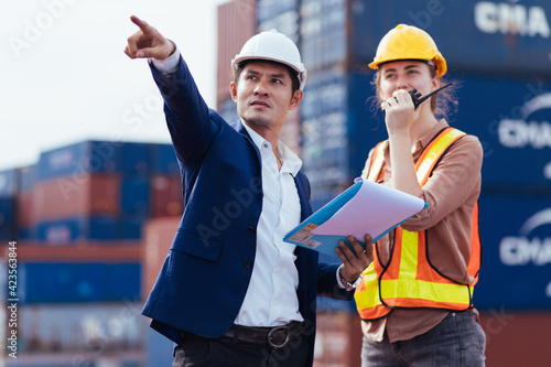 Photography smart creative foreman and engineer woman control loading containers box from cargo freight ship for import export