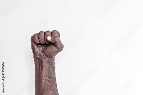 Male hand clenched into a fist on a white background. A symbol of the struggle for the rights of blacks in America. Protest against racism.  photo