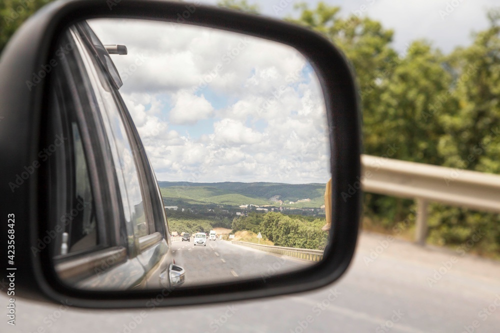 Vehicles on the road viewed from the side mirror of car