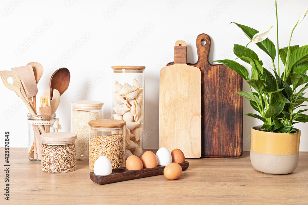 Assortment of grains, cereals and pasta in glass jars on wooden