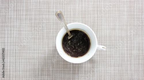 Stop motion video. The process of pouring coffee into a mug with sweetener and milk. Top view.