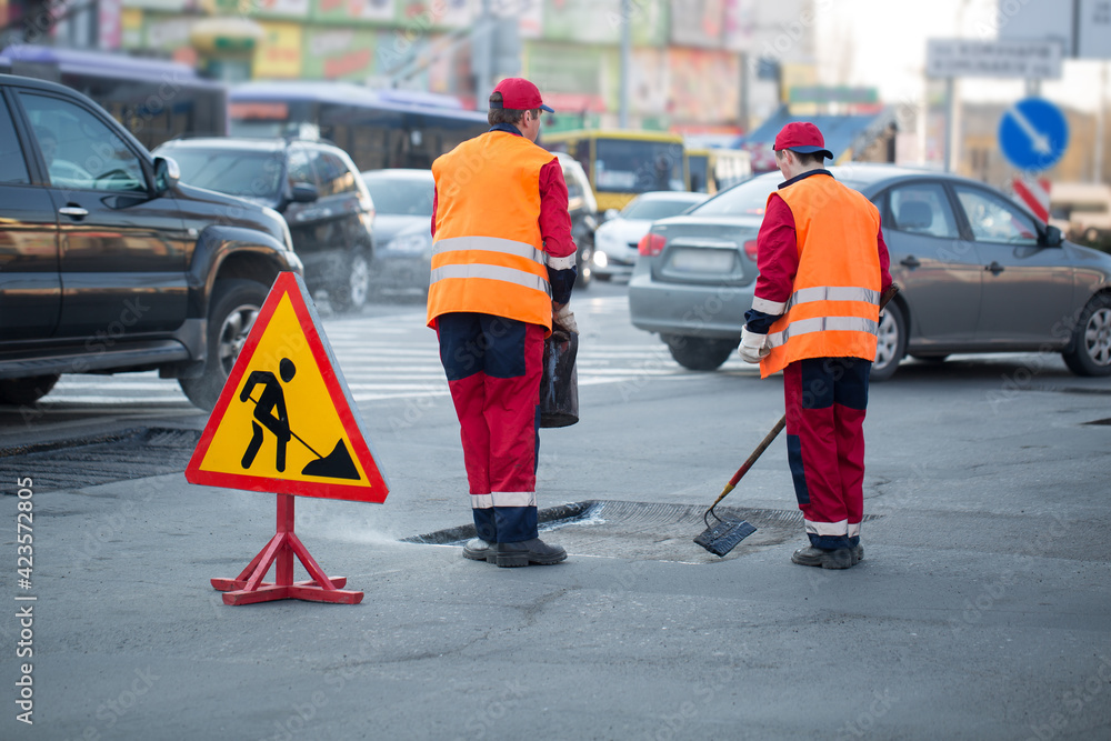 Fototapeta premium Workers are leveling asphalt on construction site road repair