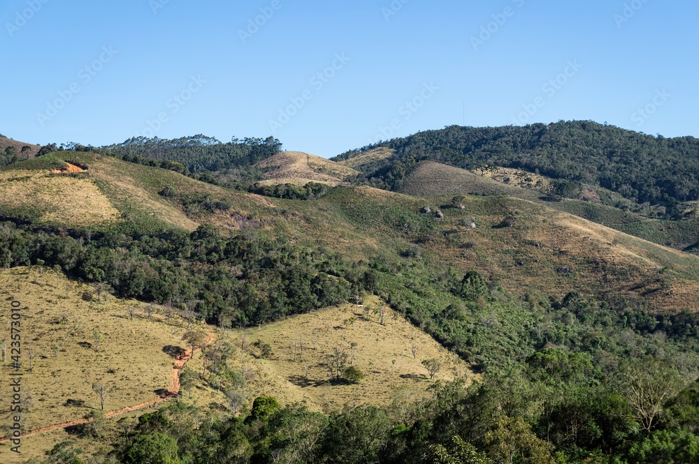 Mountains covered with fresh green vegetation during late afternoon sky saw in the countryside of Cunha, Sao Paulo - Brazil.