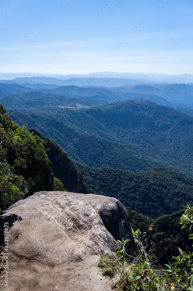 Obraz premium A cliff edge with the stunning Serra do Mar (Sea Ridge) mountain landscape at the top Pedra da Macela landmark located near Paraty village, Rio de Janeiro - Brazil.