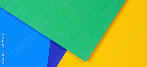 Creative abstract blue, green and yellow color geometric paper compositon background, top view