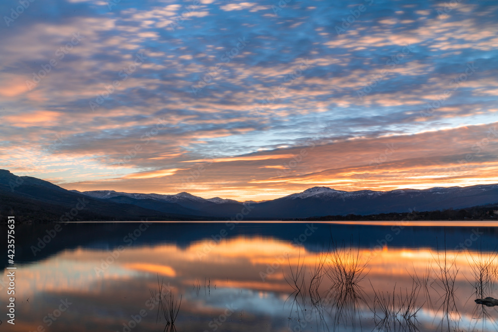 Atardecer en el lago con las montañas nevadas al fondo