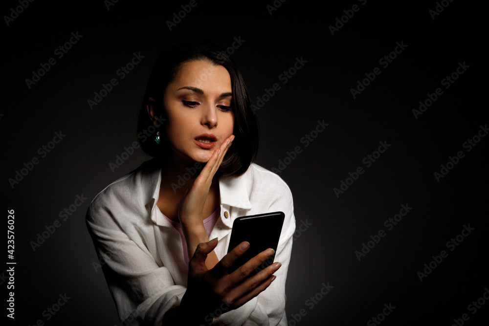 Low-key portrait of beautiful woman using mobile phone late night sleepless in the dark with smartphone and internet Low-key portrait of beautiful woman using mobile phone late night sleepless in the dark with smartphone and internet